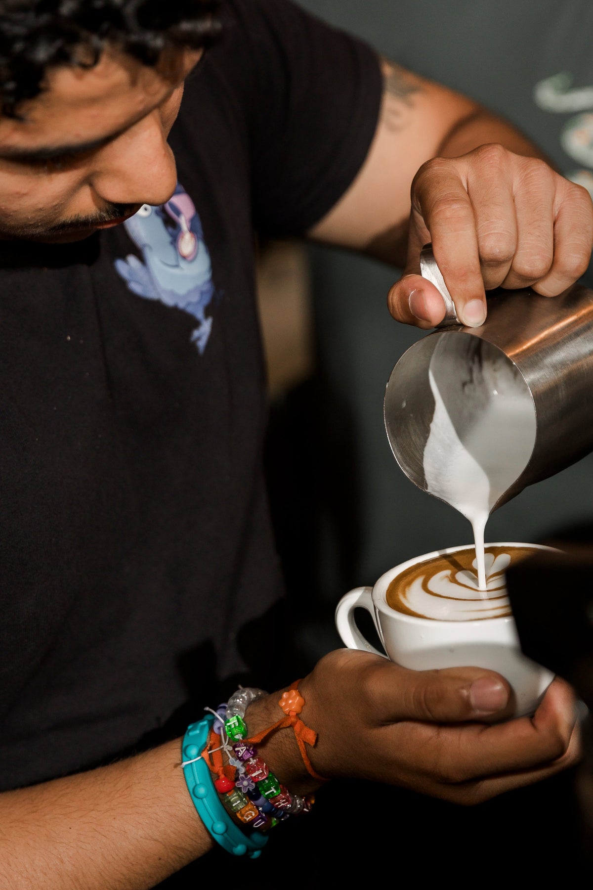 Barista pouring latte art into a cup at the Sweetleaf throwdown in New York